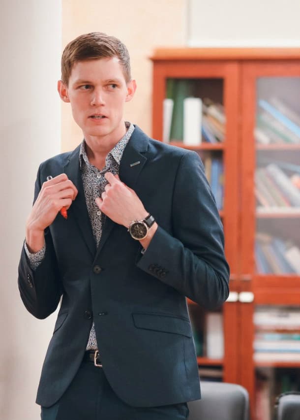 Alex Lindholm speaking and holding a photo during an educational session