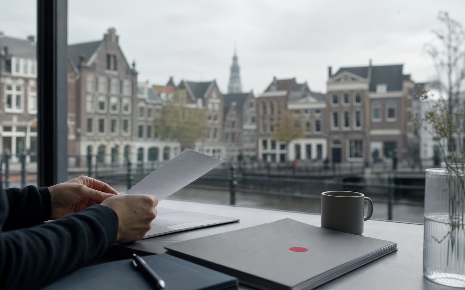 Founder reviewing a Dutch startup visa decision beside a canal